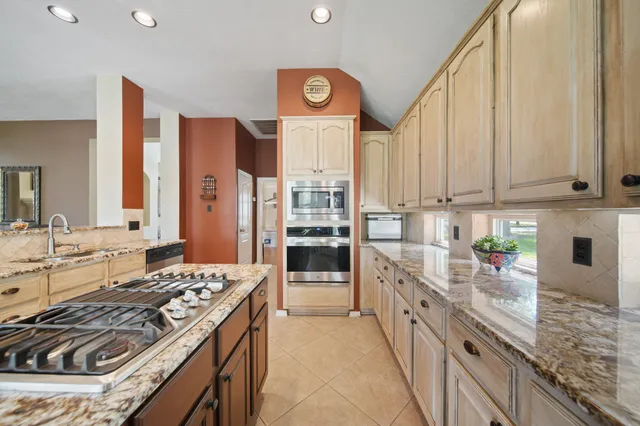 a kitchen with stainless steel appliances granite countertop a stove and a sink