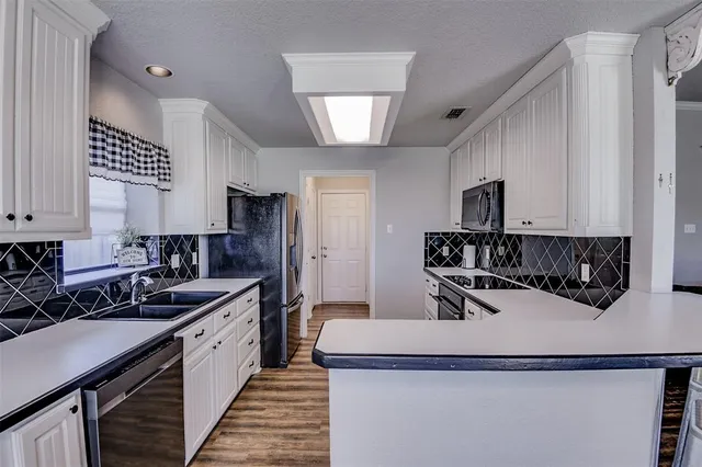 a kitchen with a sink a stove and cabinets