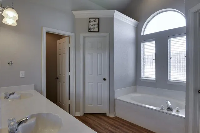 a bathroom with a tub shower and sink