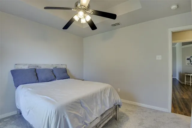 a bedroom with a large bed and a chandelier