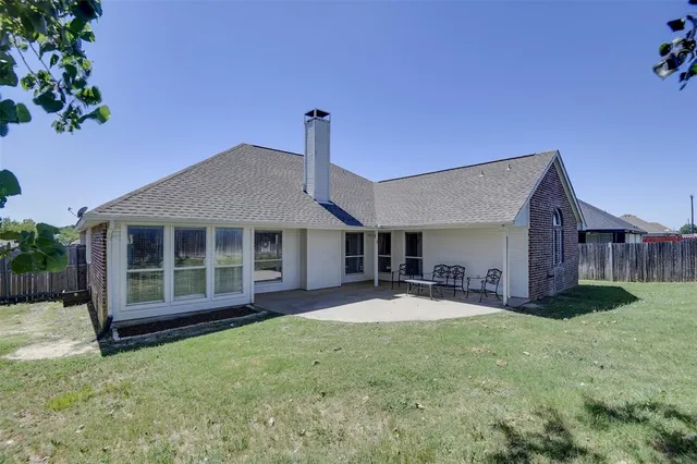 a front view of a house with a big yard and potted plants
