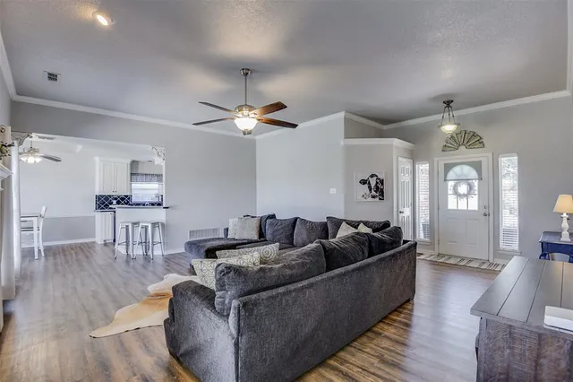 a living room with furniture and a wooden floor