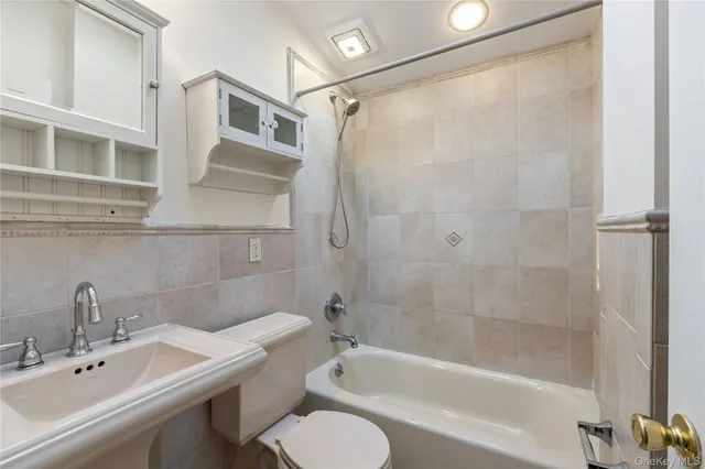 a bathroom with a bathtub shower sink vanity and toilet