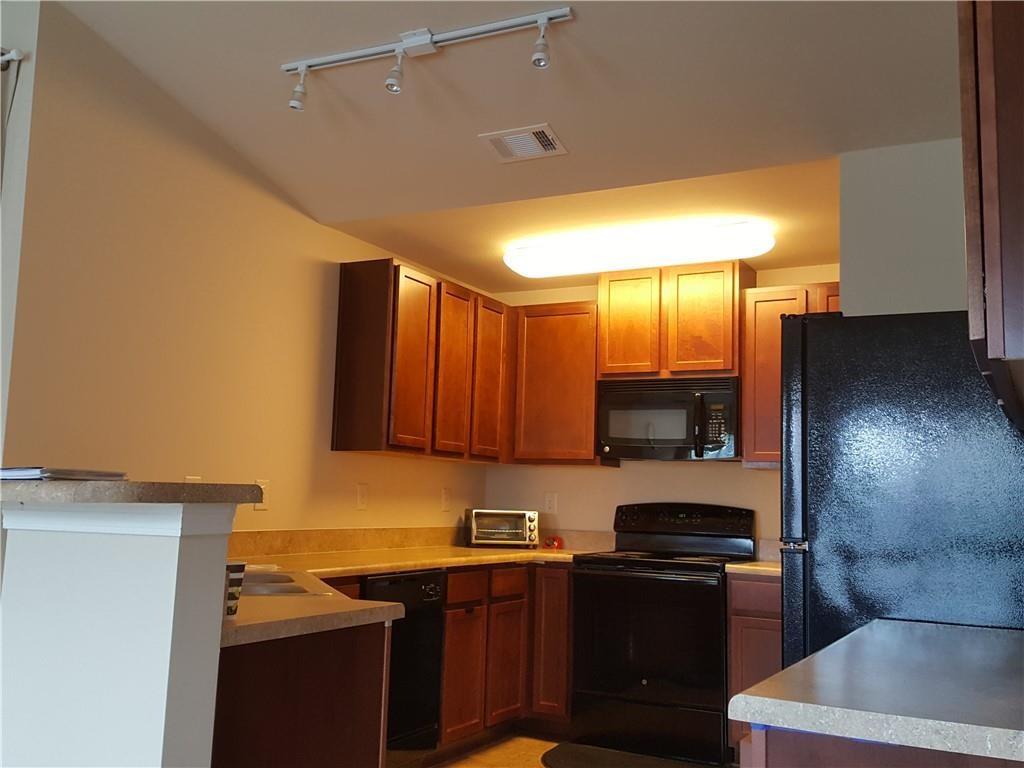 805 Pleasant Hill Road, Unit 330 Lilburn, GA 30047 - Photo 11 of 24 a kitchen with a sink a stove and a refrigerator