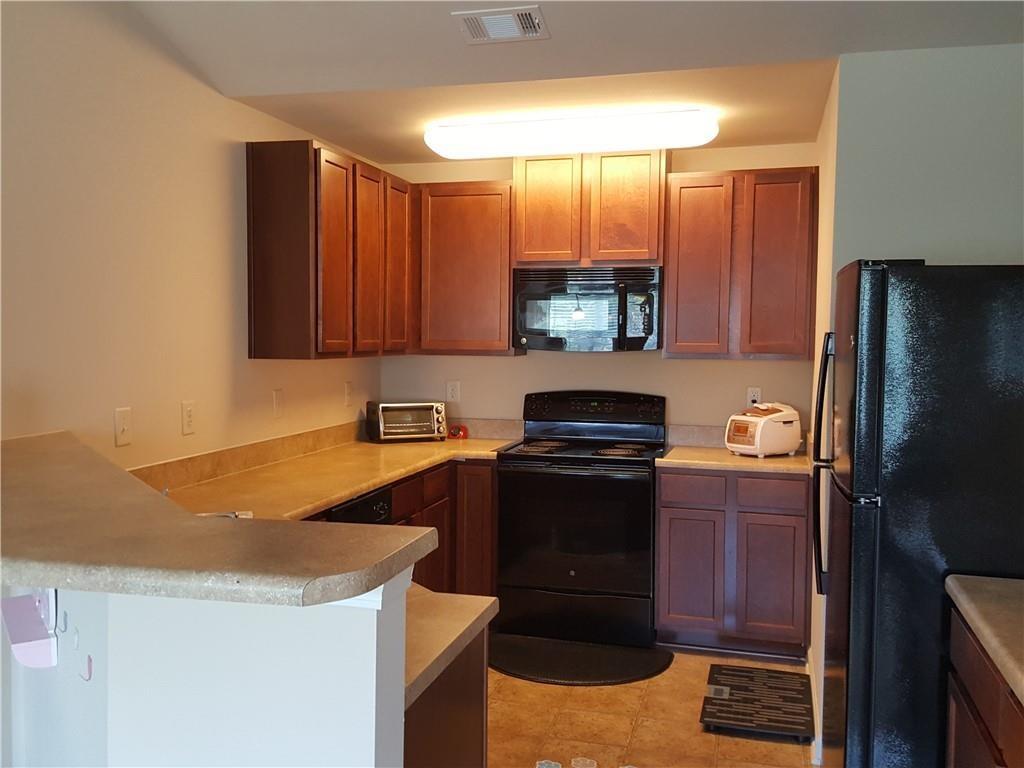 805 Pleasant Hill Road, Unit 330 Lilburn, GA 30047 - Photo 12 of 24 a kitchen with stainless steel appliances granite countertop a refrigerator stove and sink