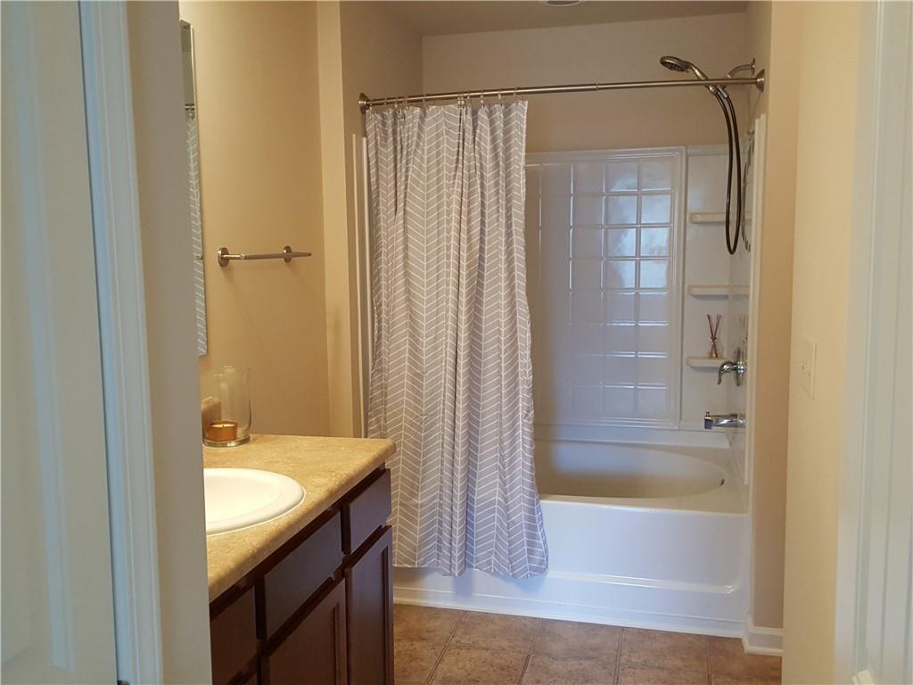 805 Pleasant Hill Road, Unit 330 Lilburn, GA 30047 - Photo 16 of 24 a bathroom with a granite countertop sink a mirror and shower