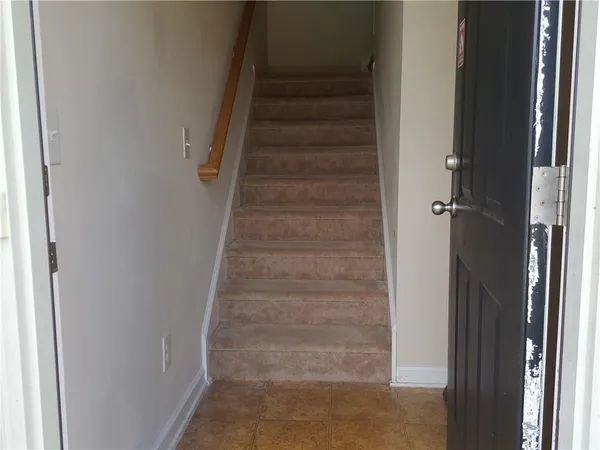 a view of staircase with white walls and white door