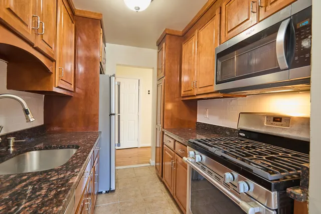 a kitchen with granite countertop a sink and a stove top oven