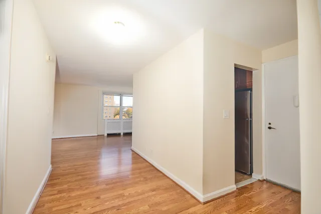 a view of empty room with wooden floor