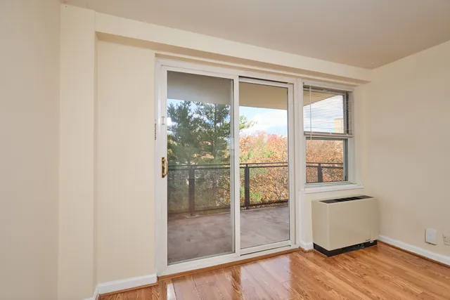 a view of a room that has wooden floor and a window