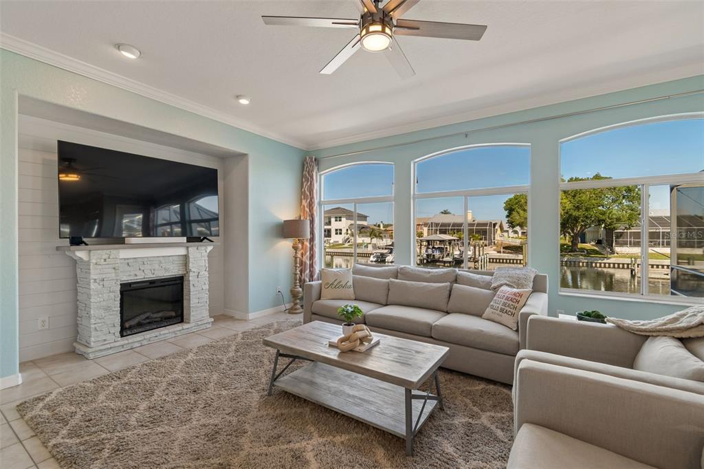 703 Bunker View Drive Apollo Beach, FL 33572 - Photo 14 of 49 a living room with furniture a fireplace and a flat screen tv