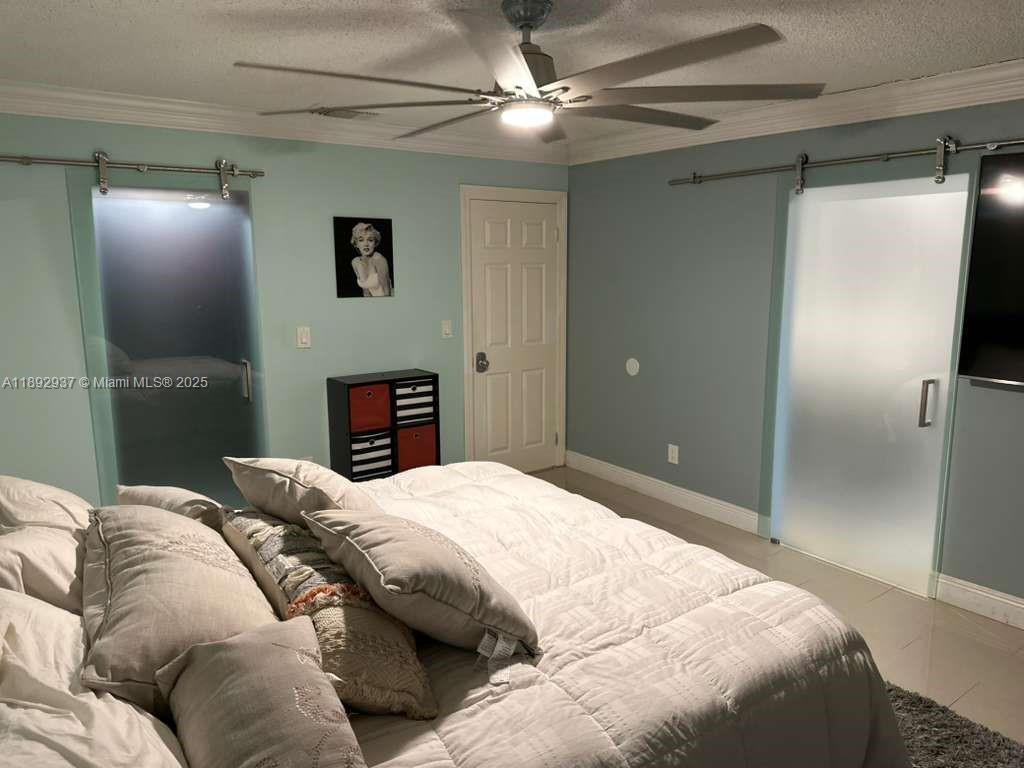 14716 Southwest 111th Terrace Miami, FL 33196 - Photo 24 of 30 a bedroom with a bed and a chandelier