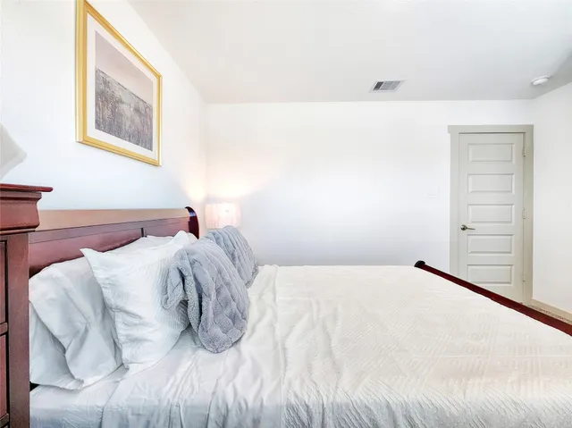 a bedroom with a bed and a painting on the wall