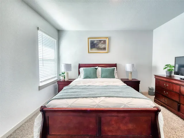 a bedroom with a bed and a potted plant