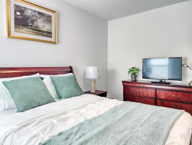 a bedroom with a bed and a flat screen tv