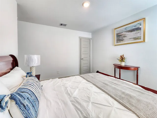 a bedroom with a bed and a painting on the wall