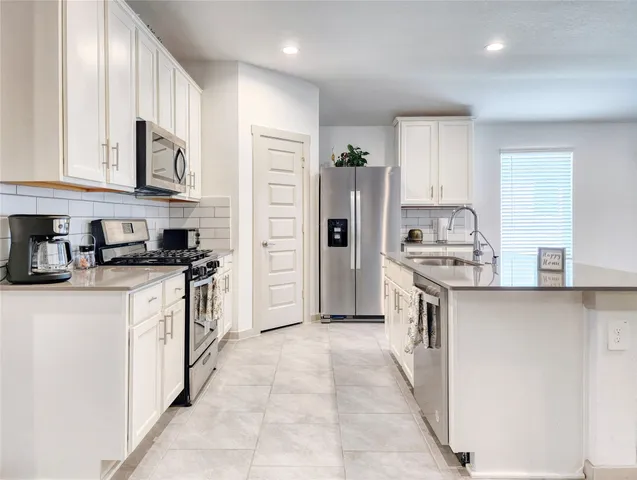 a kitchen with stainless steel appliances a refrigerator sink and cabinets