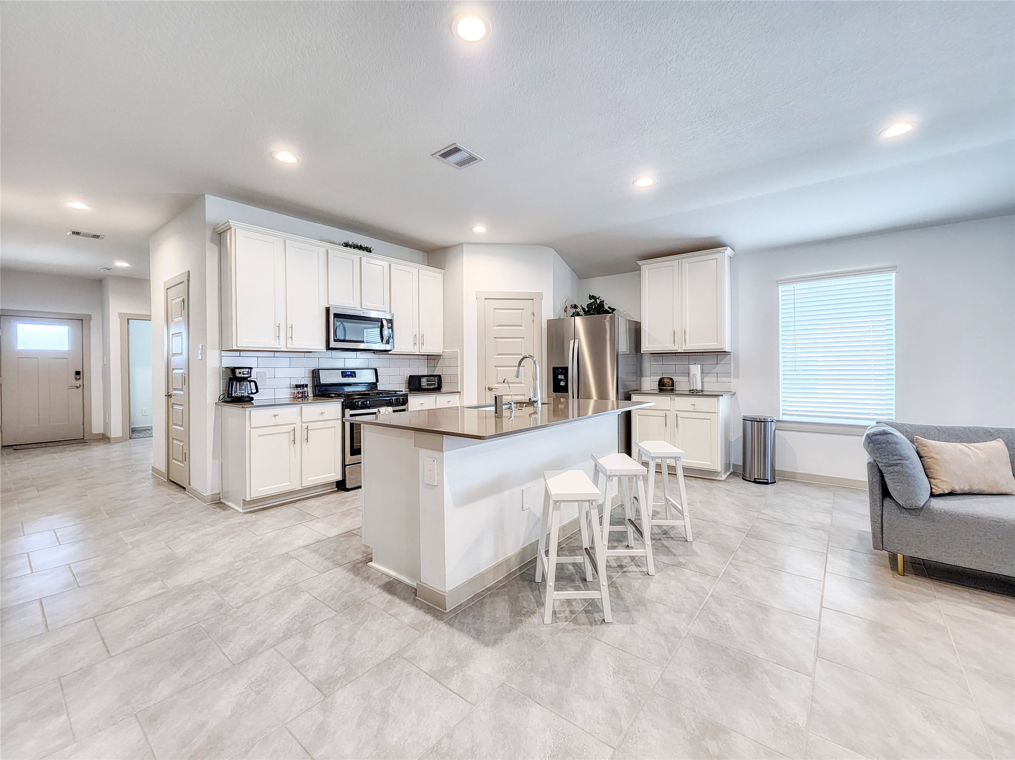 29914 Reagans Rnch Drive Katy, TX 77494 - Photo 7 of 45 a kitchen with white cabinets and stainless steel appliances