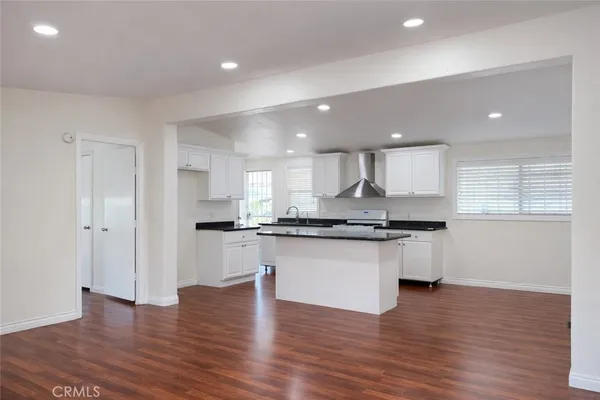 a large kitchen with granite countertop a large counter top stainless steel appliances and cabinets