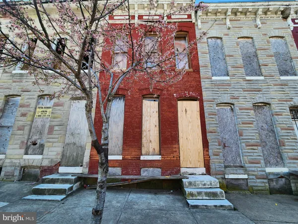 a front view of a building with large trees