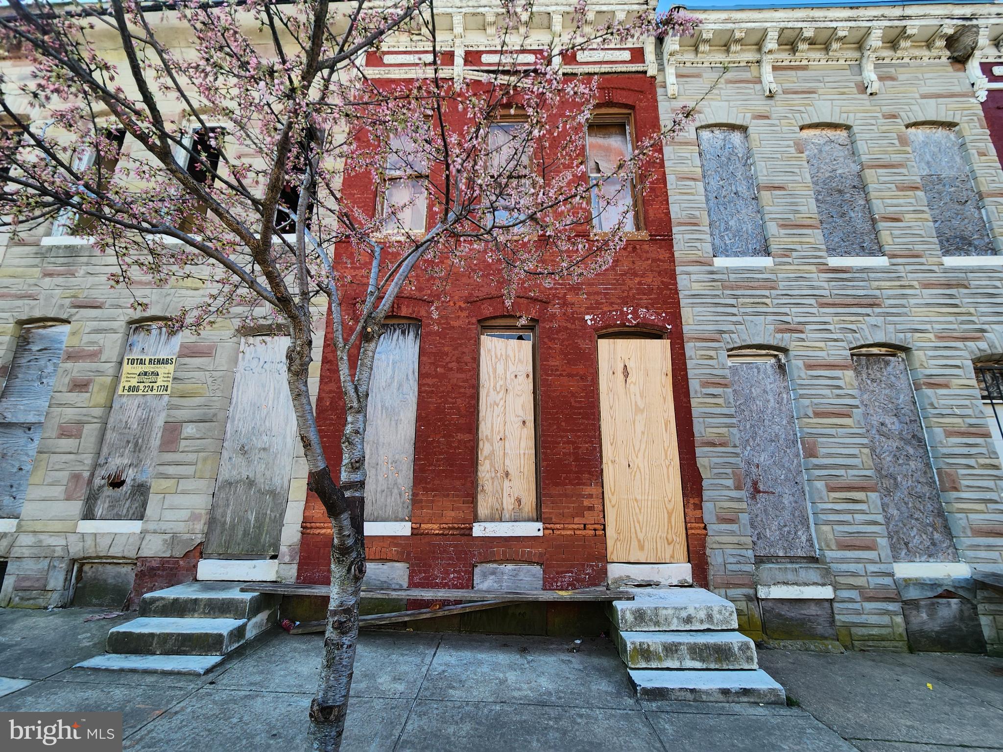 a front view of a building with large trees