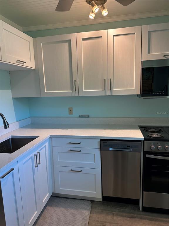 11485 Oakhurst Road, Unit 200114 Largo, FL 33774 - Photo 13 of 40 a kitchen with cabinets appliances and a sink