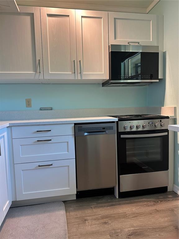 11485 Oakhurst Road, Unit 200114 Largo, FL 33774 - Photo 10 of 40 a kitchen with stainless steel appliances granite countertop a stove microwave and cabinets