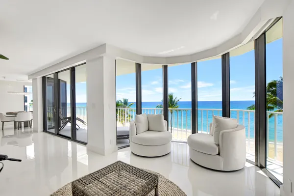 a living room with furniture and large windows