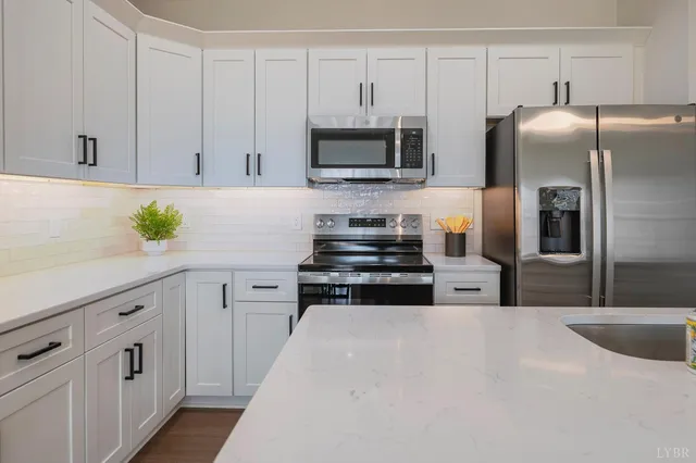 a kitchen with stainless steel appliances a refrigerator sink and microwave