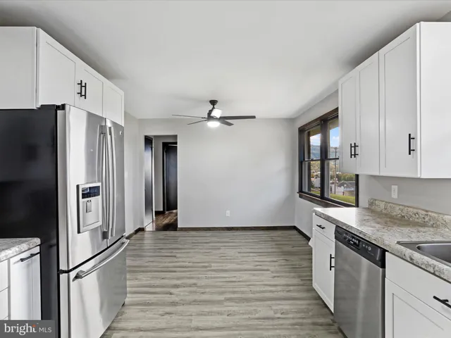 a kitchen with granite countertop a refrigerator and a stove top oven
