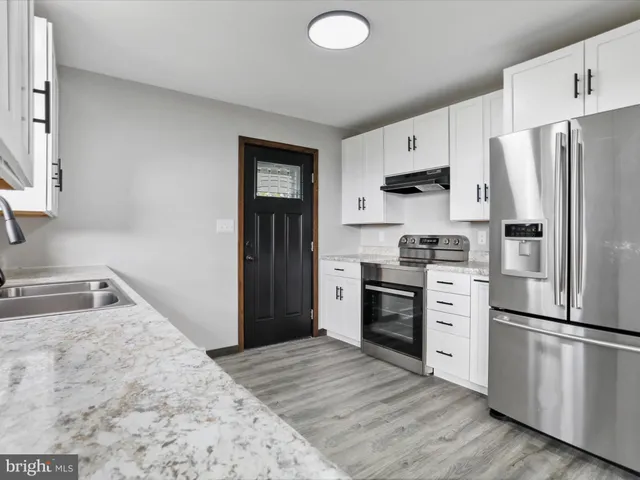 a kitchen with a refrigerator stove and wooden cabinets
