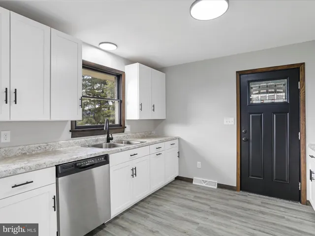 a kitchen with a sink cabinets and wooden floor