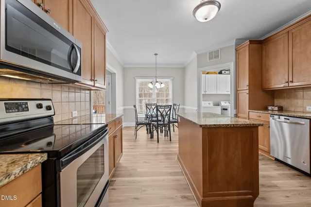 a kitchen with stainless steel appliances granite countertop a stove and a microwave