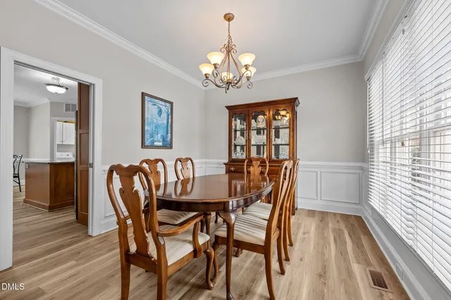 a dining room with furniture a chandelier and wooden floor