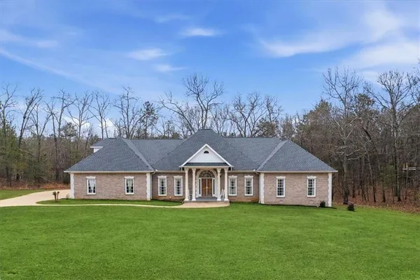 a front view of a house with yard and trees