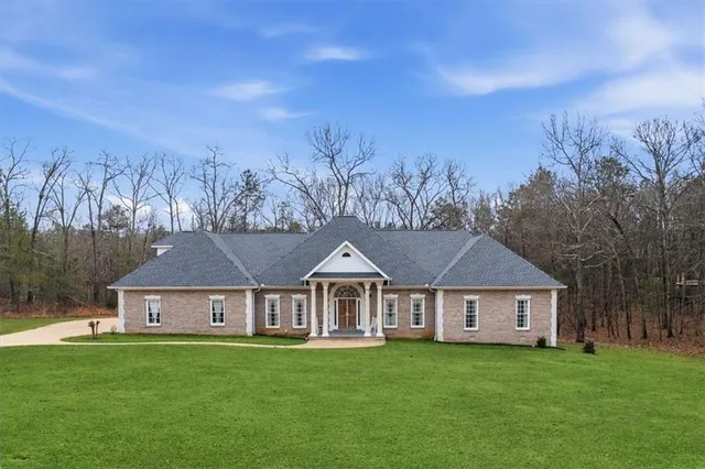 a front view of a house with yard and trees