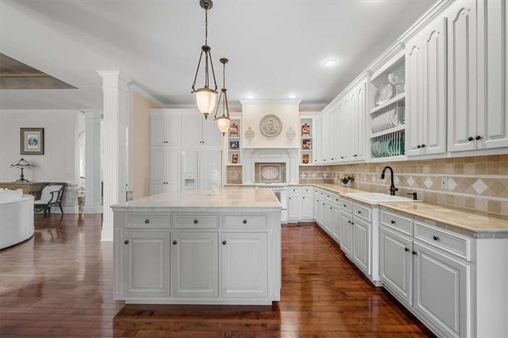 96 Windchime Way Northeast Rome, GA 30161 - Photo 16 of 57 a large white kitchen with lots of counter space wooden floor and stainless steel appliances