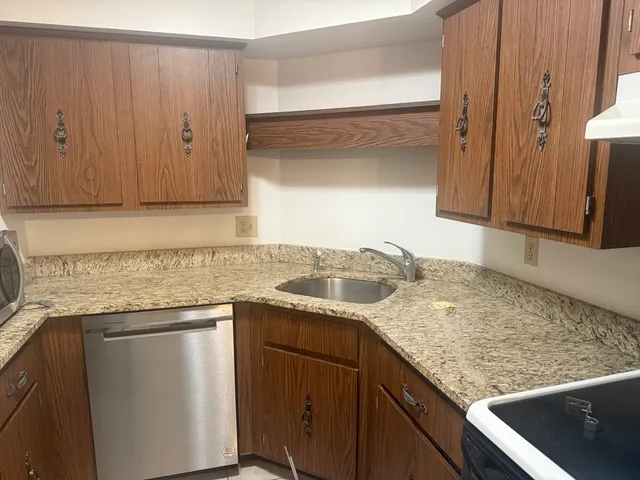 a kitchen with granite countertop a sink and cabinets
