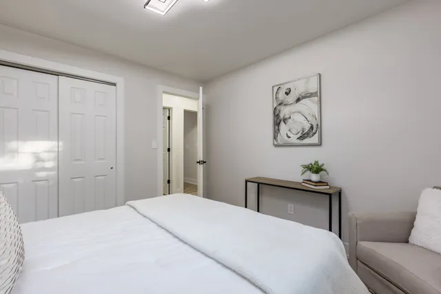 a bedroom with a bed and painting on the wall