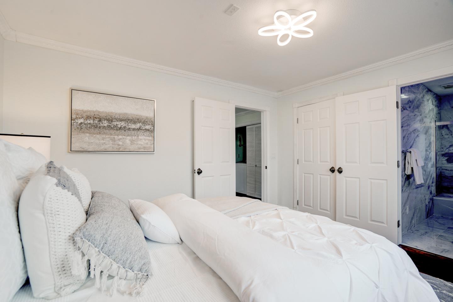 350 Buckingham Way Pacifica, CA 94044 - Photo 36 of 68 a bedroom with a bed and a chandelier