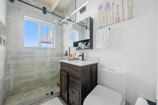 a bathroom with a sink toilet vanity and shower