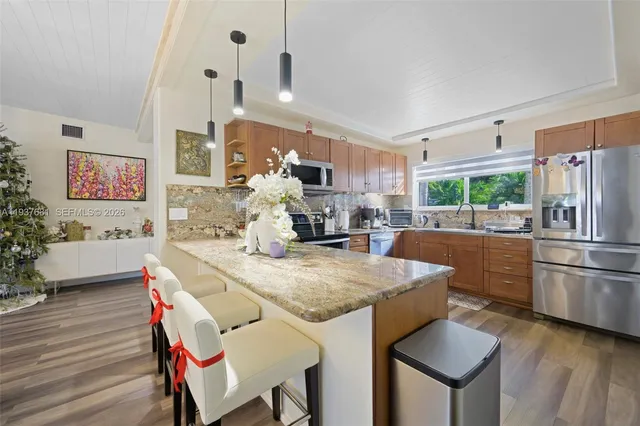 a kitchen with stainless steel appliances granite countertop a sink refrigerator and cabinets