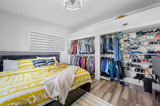 a bedroom with a bed a books and walk in closet