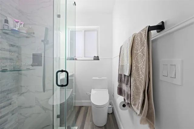 a bathroom with a toilet and a shower
