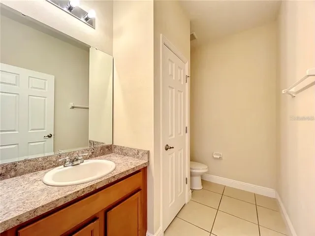 a bathroom with a granite countertop sink a toilet and a mirror