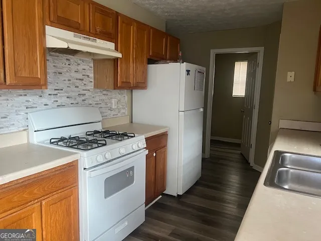 a kitchen with a stove a refrigerator and a sink