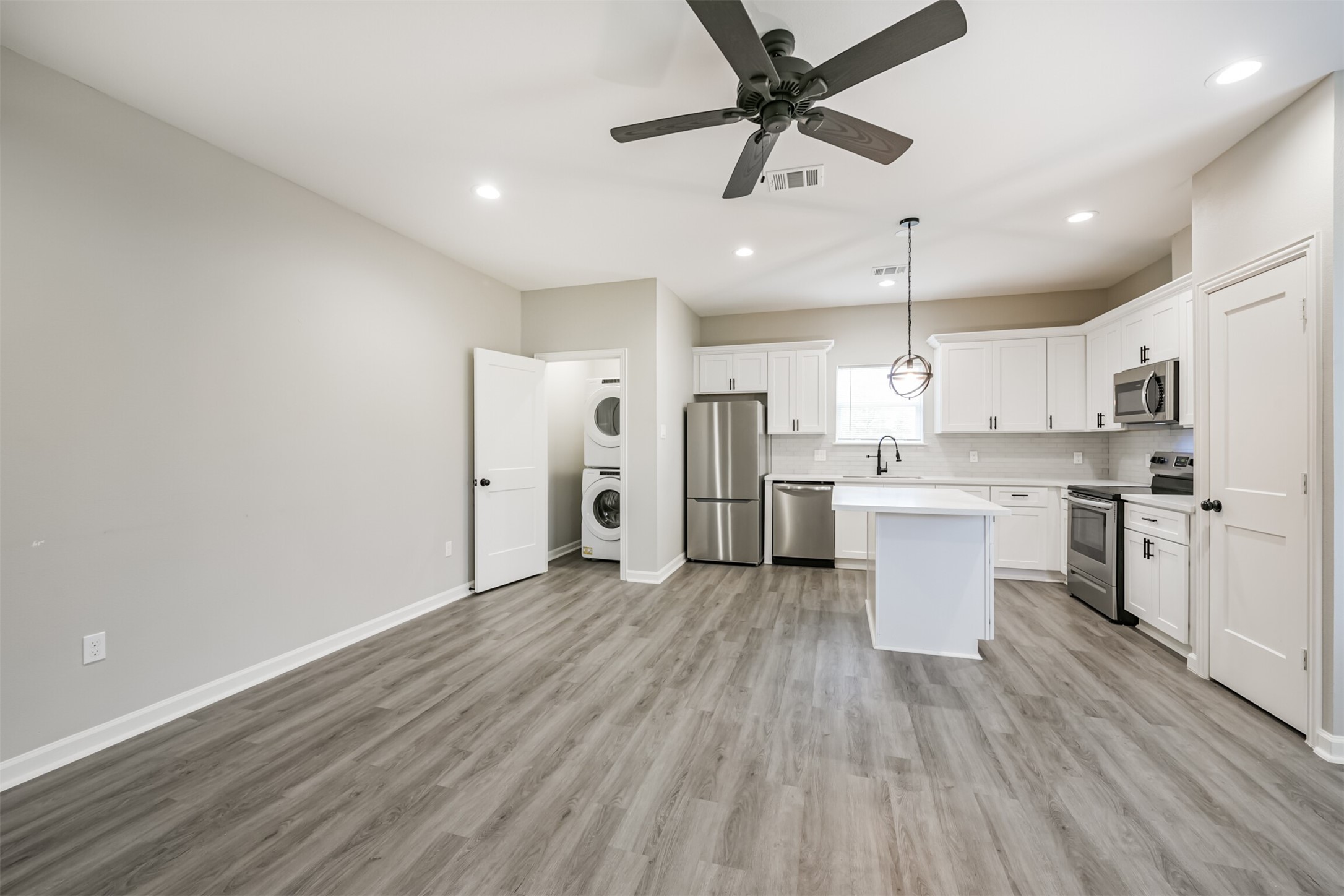 4405 Mallow Street Houston, TX 77051 - Photo 21 of 21 a large white kitchen with a refrigerator a sink dishwasher a stove and white cabinets with wooden floor