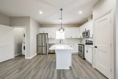 a kitchen with granite countertop white cabinets and sink