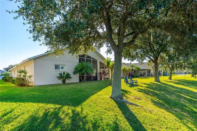 a view of a house with big yard and a large tree