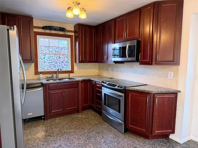 a kitchen with stainless steel appliances granite countertop a refrigerator stove and sink